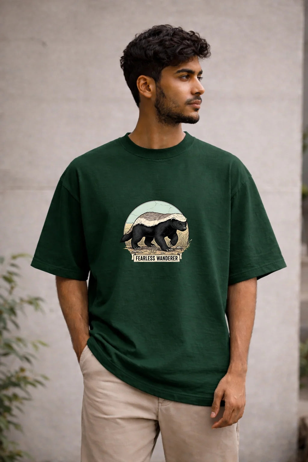 Man wearing a green t-shirt with a bear graphic and text, standing against a neutral background.