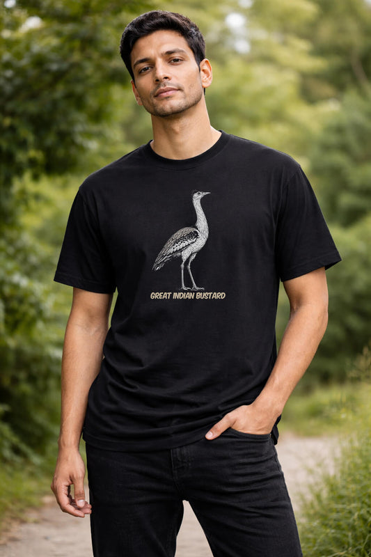 Man wearing a black t-shirt with a bird graphic and text in a forest setting
