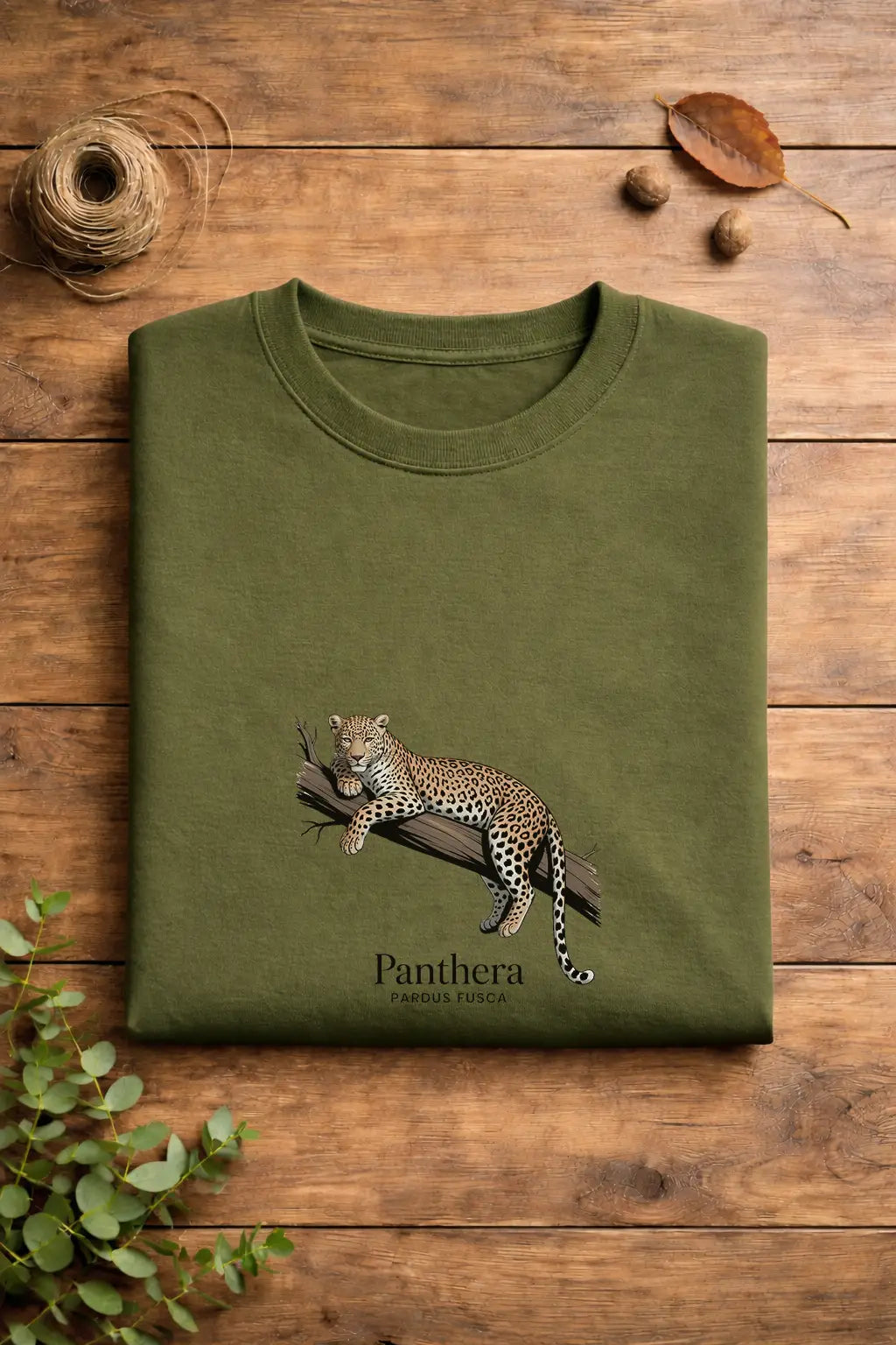 Green t-shirt with a panther design on a wooden surface