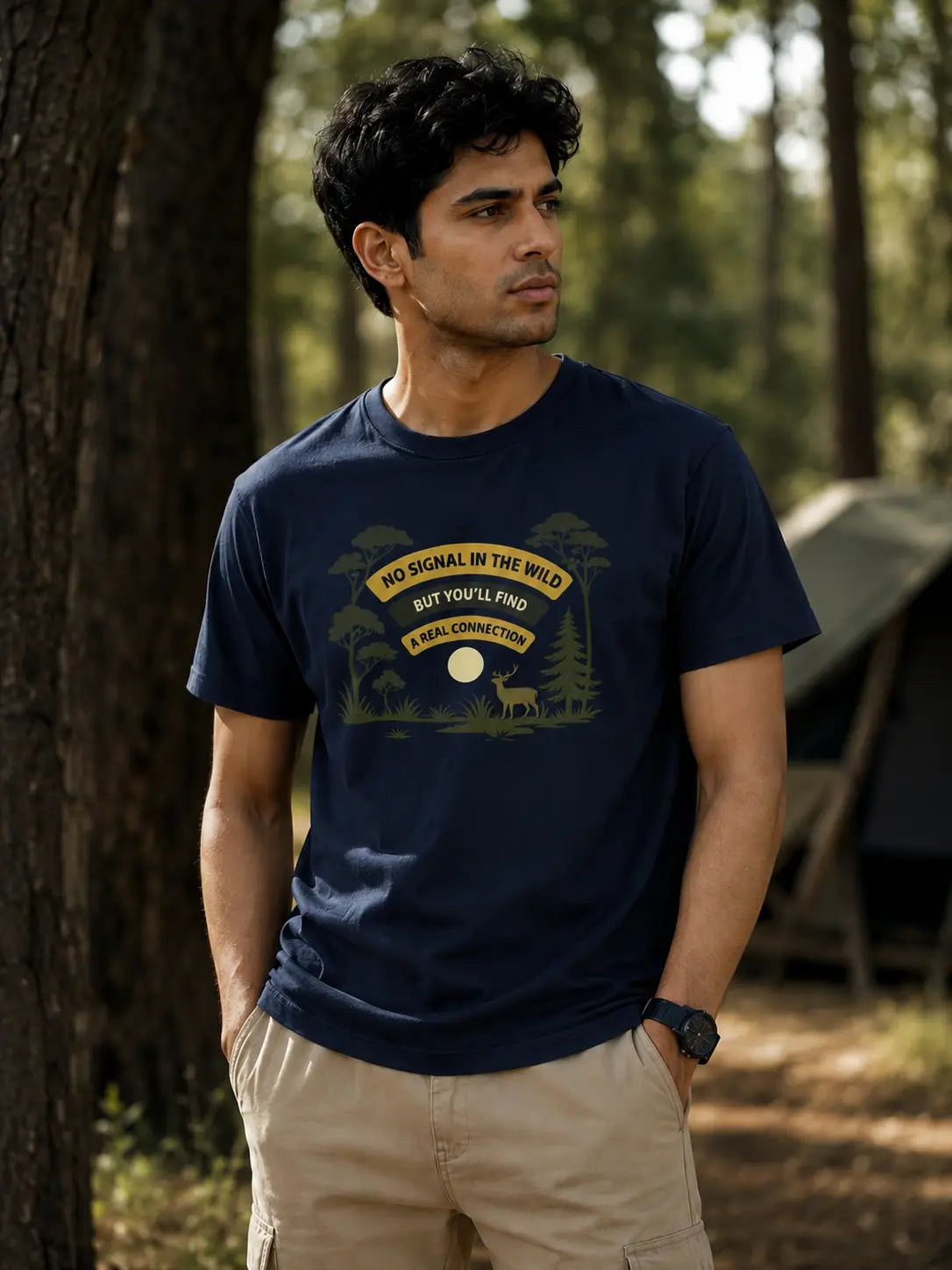 Man wearing a navy blue t-shirt with a graphic design in a forest setting