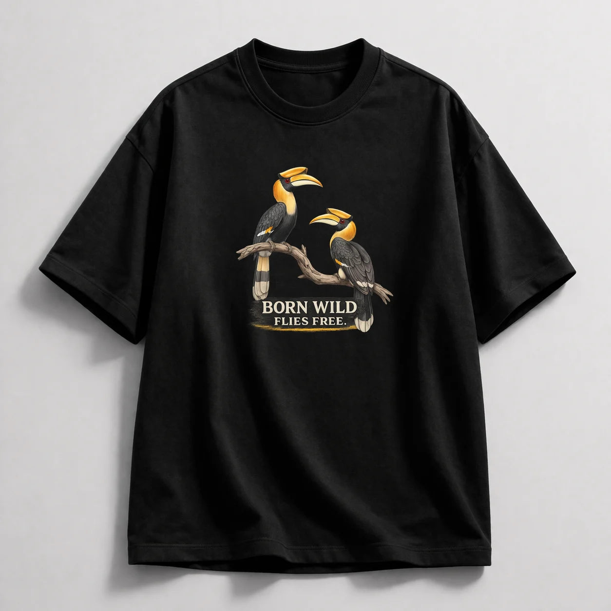 Black t-shirt with bird design and 'Born Wild Flies Free' text on a light gray background
